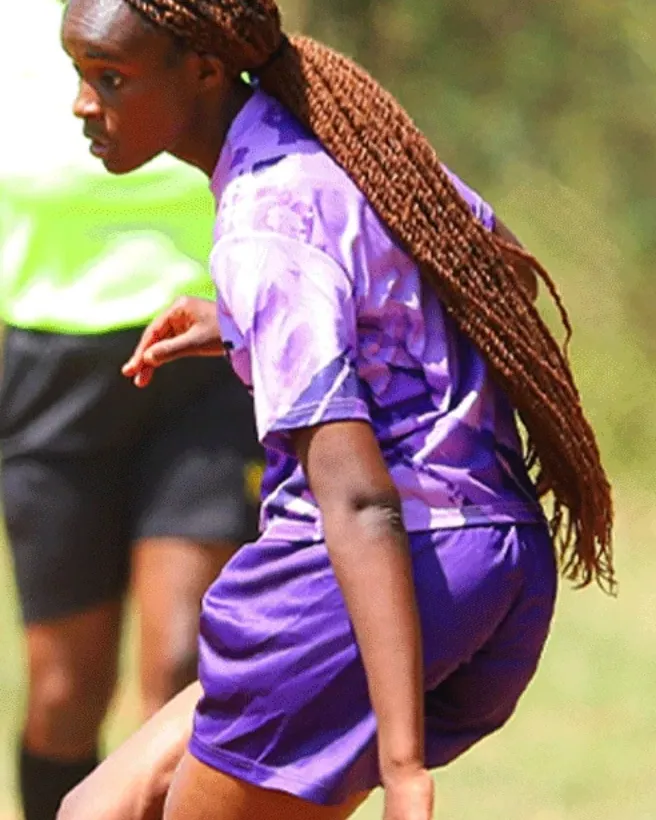 A player in purple driving the ball up the wing