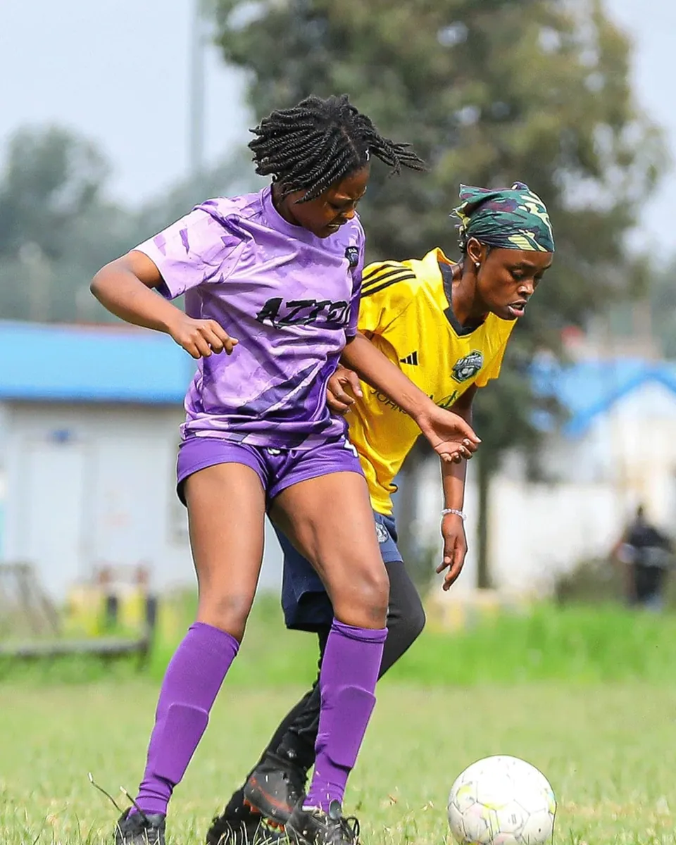 An Azidi player shielding the ball from a defender in yellow