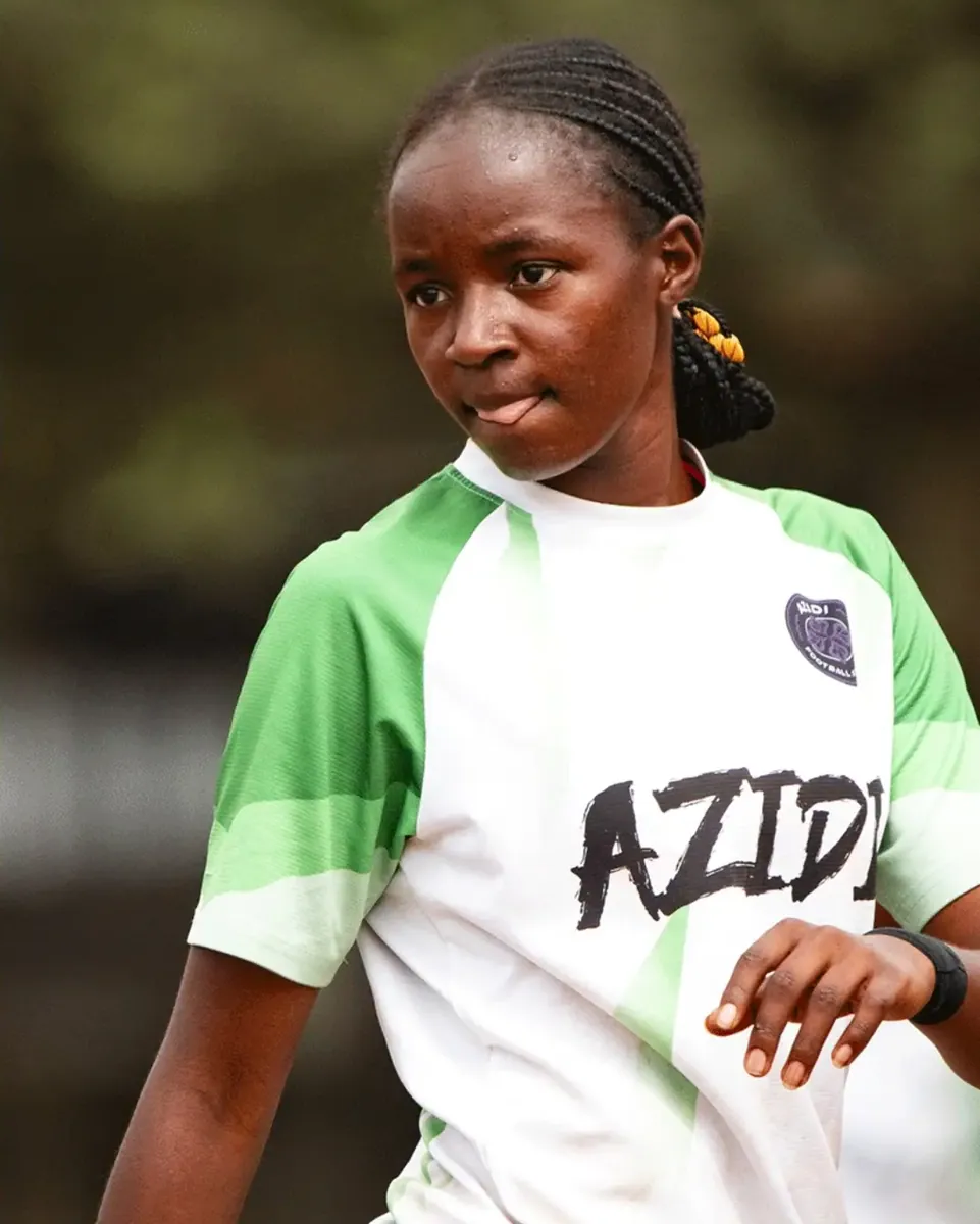 A player in the green and white Azidi shirt, looking straight at the camera