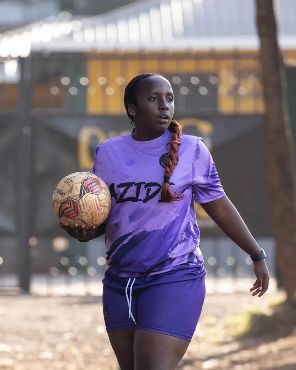 A player standing with the ball on her hip before kick-off